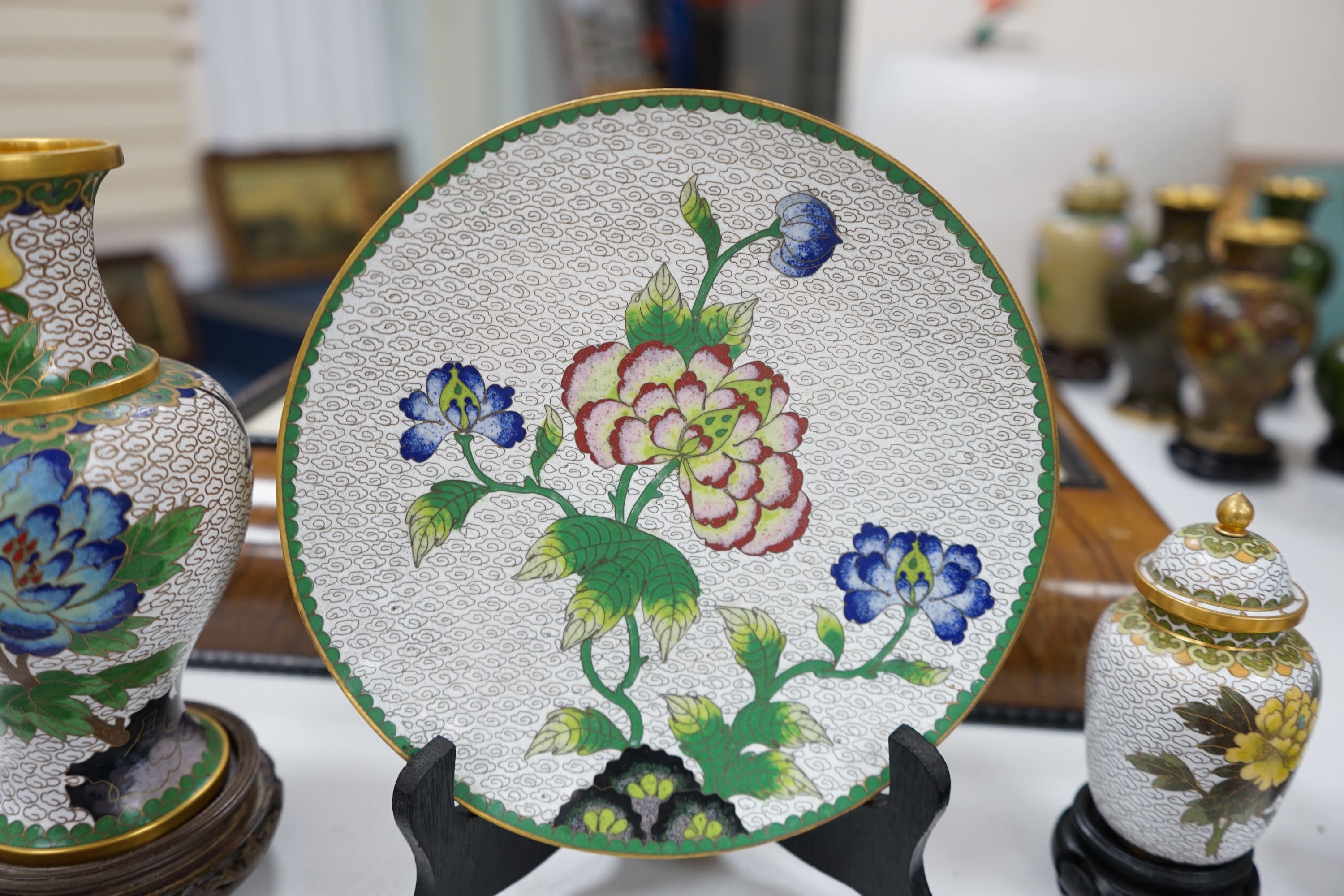 A collection of Chinese cloisonné enamel vases, pots etc., all worked on a white background in floral designs, plate, 20cm diameter. Condition - good